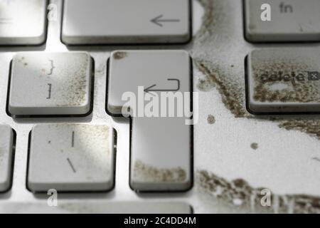 Nahaufnahme einer sehr schmutzigen Desktop-Tastatur von einem bekannten Computer- und Smartphone-Anbieter.Anzeige von Schmutz auf verschiedenen Tasten. Stockfoto