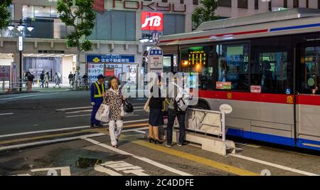 Pendler Schlange warten auf einen Bus in Shibuya Station, Tokio, Japan in der Nacht. Stockfoto