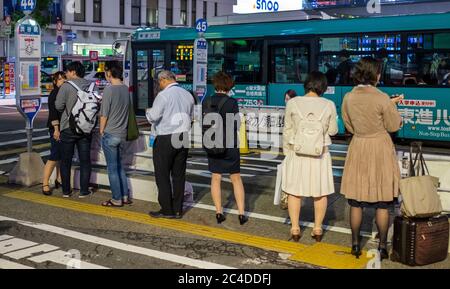 Pendler Schlange warten auf einen Bus in Shibuya Station, Tokio, Japan in der Nacht. Stockfoto