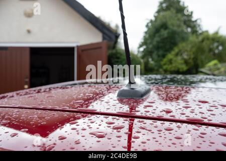 Flacher Fokus eines neuen Autos, zeigt Wassertropfen auf seinem Dach und Spoiler. Stockfoto