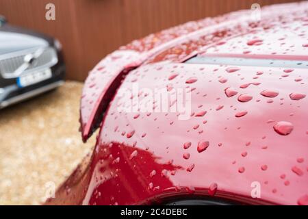 Flacher Fokus eines neuen Autos, zeigt Wassertropfen auf seinem Dach und Spoiler. Stockfoto