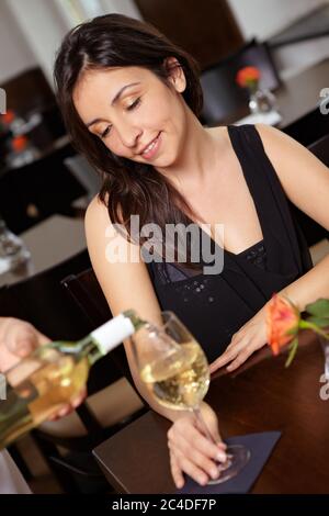 Frau im Restaurant schaut auf ihr Weinglas Stockfoto