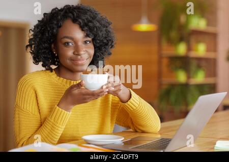 Junge Geschäftsfrau mit Kaffeepause während der Arbeit im Café Stockfoto