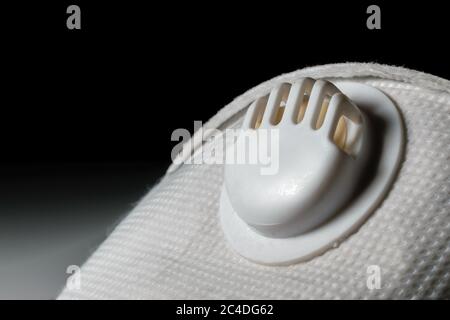 Nahaufnahme der Atemschutzmaske einer N95 Maske für COVID 19. Dunkler Hintergrund Stockfoto