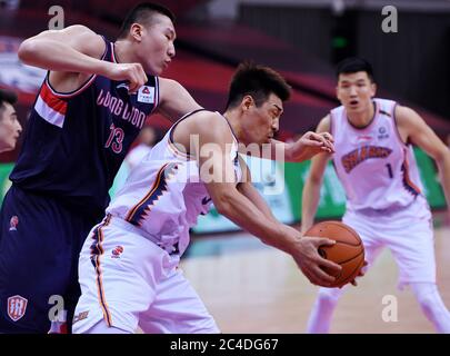 Qingdao, Chinas Provinz Guangdong. Juni 2020. Li Yanzhe (L) von Guangzhou Loong Lions verteidigt einen Spieler der Shanghai Sharks während eines Spiels zwischen Shanghai Sharks und Guangzhou Loong Lions bei der neu wiederaufgenommenen Liga 2019-2020 Chinese Basketball Association (CBA) in Dongguan, südchinesische Provinz Guangdong, 26. Juni 2020. Quelle: Li Ziheng/Xinhua/Alamy Live News Stockfoto