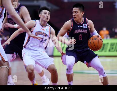 Qingdao, Chinas Provinz Guangdong. Juni 2020. Chen Yingjun (R) von Guangzhou Loong Lions versucht, die Verteidigung der Shanghai Sharks während eines Spiels zwischen Shanghai Sharks und Guangzhou Loong Lions in der neu wiederaufgenommenen Liga der Chinesischen Basketball Vereinigung (CBA) 2019-2020 in Dongguan, südchinesische Provinz Guangdong, zu durchstehen, 26. Juni 2020. Quelle: Li Ziheng/Xinhua/Alamy Live News Stockfoto