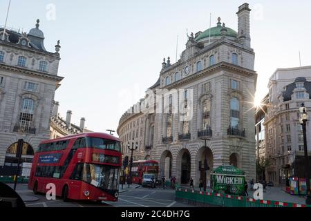 Mit weiteren 149 Berichten, die in den letzten 24 Stunden an Coronavirus starben, was die Todesrate in Großbritannien auf 43,320 ansteigen lässt, der Kreuzung von Piccadilly Circus und Regent Street, wo grüne Fußgänger-soziale Abstandsbarrieren während der Covid-Pandemie am 25. Juni 2020 in London, England, den Straßenbelag erweitern. Stockfoto
