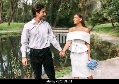 Schöne Braut Und Bräutigam Zu Fuß Halten Hände In Schönen Park Stockfoto
