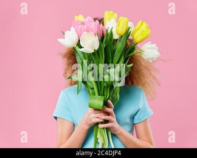 Muttertag, eine junge Frau mit einem Kind posiert im Studio mit Blumen Stockfoto