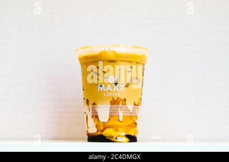 Ein illustrativer Editorial des Maxx Coffee Iced Coffee mit Karamell in der Mitte mit einem hellrosa Hintergrund. Stockfoto