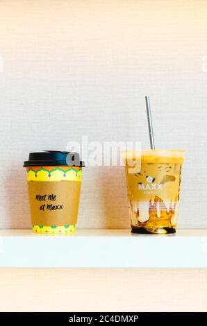 Ein illustrativer Leitartikel des Maxx Coffee Cappuccino und Iced Coffee mit Karamell und einem Edelstahlstroh in der Mitte mit einem hellrosa Hintergrund Stockfoto