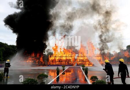 Yangon, Myanmar. Juni 2020. Feuerwehrleute sprühen Wasser auf einen brennenden Stapel beschlagnahmter Drogen während einer Zeremonie in Yangon, Myanmar, am 26. Juni 2020. In Myanmar wurden am Freitag in Yangon, Mandalay und im Bundesstaat Shan Betäubungsmittel im Wert von über 839 Millionen US-Dollar verbrannt, was den Internationalen Tag gegen Drogenmissbrauch und illegalen Handel anbetrifft. Quelle: U Aung/Xinhua/Alamy Live News Stockfoto