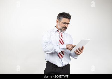 Geschäftsmann mittleren Alters, der auf den Bildschirm auf einem weißen Hintergrund schaut Stockfoto