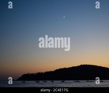 Eine Reihe von Booten auf dem Meer in Oludeniz, Türkei, bei Dämmerung Stockfoto