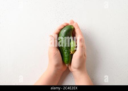 Hässliche Gurken in Kinderhände. Konzept Bio-Gemüse. Blick von oben. Stockfoto