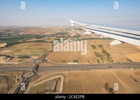 Blick durch das Fenster von Flugzeugen während des Fluges. Flugzeugflügel über blauen Himmel, Kreuzung und Stadtbild Hintergrund. Platz kopieren. Stockfoto