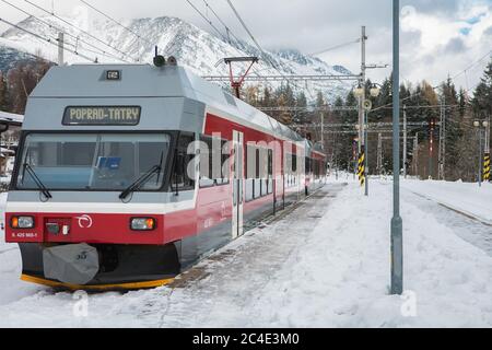 STRBSKE PLESO, SLOWAKEI - 1. NOVEMBER 2017: Moderner Elektrozug wartet auf Passanten im verschneiten Bahnhof von Strbske Pleso in der Slowakei Stockfoto