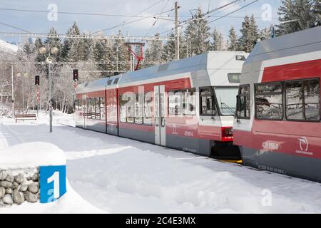 STRBSKE PLESO, SLOWAKEI - 1. NOVEMBER 2017: Elektrozug wartet auf Passanten im verschneiten Bahnhof von Strbske Pleso in der Slowakei Stockfoto