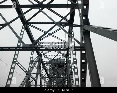 Metallkonstruktion der Eisenbahnbrücke mit dem aufsteigenden Mittelteil für die Durchfahrt von Schiffen. Blick von unten vom Fenster des Autos. Architektur, Designelemente Stockfoto