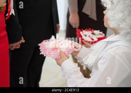 Kinder in den Kleidern der Engel bringen Eheringe zur Hochzeit und zum Bräutigam Stockfoto