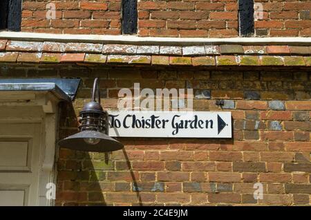 Gemaltes Schild an einer alten Ziegelwand, die auf den Cloiser Garden, Dorchester Abbey, Dorchester on Thames, Oxfordshire, UK, zeigt Stockfoto