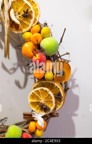 Fragment eines Neujahrskranzes mit Zimt, Anis, Zitrone, Pinienzapfen und kleinen künstlichen Früchten, Nahaufnahme Stockfoto