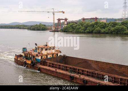 GOA, INDIEN - 05. Mai 2020: Lastkähne, die Bergbauerz für den Export in Borim, Goa transportieren. Stockfoto