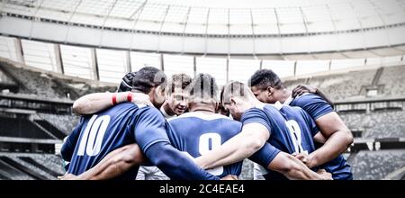 Digitale Composite-Bild von Team von Rugby-Spieler in einem Huddle im Sportstadion stehen Stockfoto