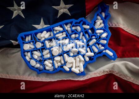 Konzept für Gesundheitsversorgung, Opioid-Epidemie und Drogenmissbrauch mit der Karte der USA gefüllt mit Oxycodon und Hydrocodon pharmazeutischen Pillen auf der amerikanischen Flagge Stockfoto