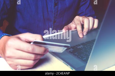 Nahaufnahme asiatischen jungen Mann mit Laptop und halten Kreditkarte mit Online-Shopping. Stockfoto