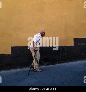 Älterer Einheimischer, der in Siena eine steile Fußstraße hinaufgeht. Italien. Stockfoto
