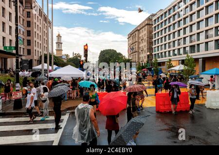 Menschen protestieren gegen die Brutalität der Polizei und feiern den Elften Juni auf dem Black Lives Matter Plaza an einem regnerischen Nachmittag in Washington, DC, USA Stockfoto