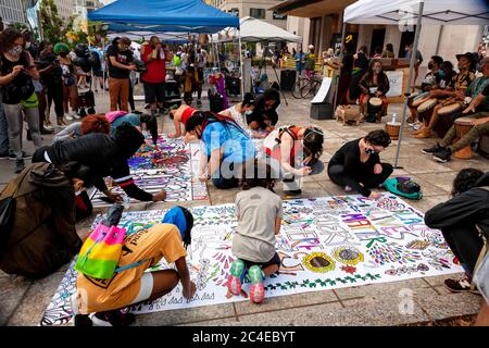 Viele junge Demonstranten arbeiten an einem regnerischen Nachmittag an Wandgemälden, die am Black Lives Matter Plaza / Lafayette Square, Washington, DC, USA, aufgehängt werden Stockfoto