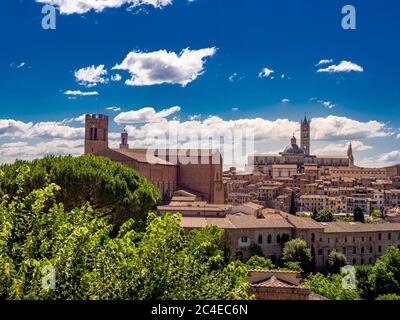Nordwestliche Seite der Kathedrale von Siena mit der Basilika Cateriniana San Domenico auf der linken Seite. Siena, Italien. Stockfoto