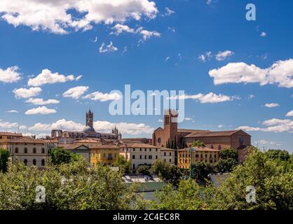 Nordwestliche Seite des Siena Doms mit der Basilika Cateriniana San Domenico auf der rechten Seite. Siena, Italien. Stockfoto