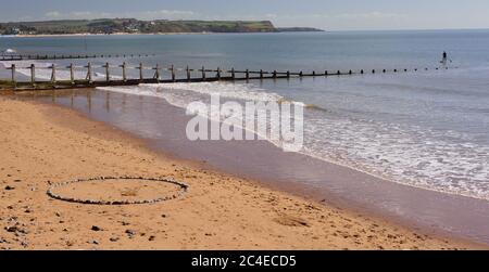 Ein Steinkreis am Strand von Dawlish Warren, der Richtung Exmouth schaut. Stockfoto