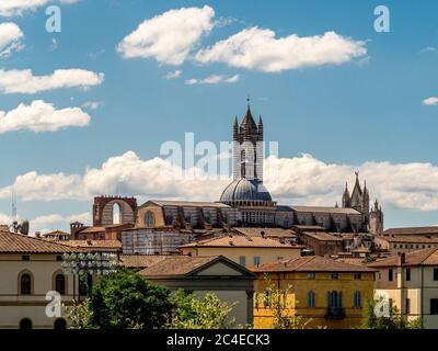 Erhöhte Sicht auf die Nordwestseite der Kathedrale von Siena, zusammen mit dem Baptisterium und dem Facciatone. Siena, Italien. Stockfoto