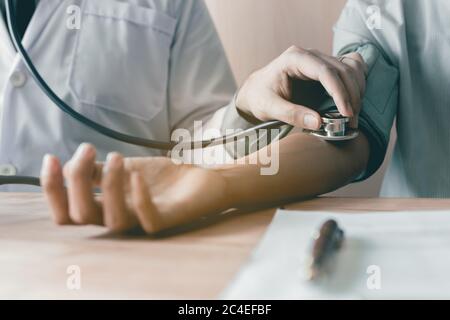 Arzt mit Stethoskop Tippen Sie auf den Arm des Patienten. Stockfoto