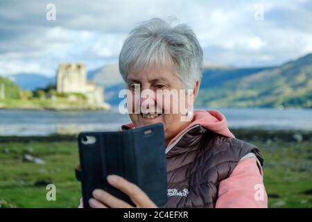 Lady fotografiert auf Eilean Donan Castle Loch Duich Highland Scotland Stockfoto