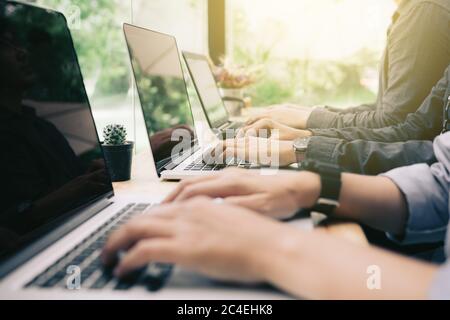 Multirassische Gruppe von Studenten, die auf dem Laptop im Coworking Space im Café kodieren. Stockfoto