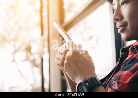 Asiatischer Mann mit Smartphone zu Hause. Stockfoto
