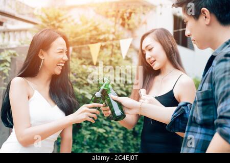Outdoor-Party Gruppe von glücklichen Freunden Toasting mit Bierflaschen im Garten zu Hause. Stockfoto