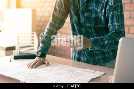 Architekt steht auf dem Smartphone und arbeitet im modernen Büro. Stockfoto