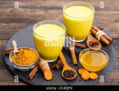 Kurkuma-Latte mit goldener Milch mit Honig und Zimt Stockfoto