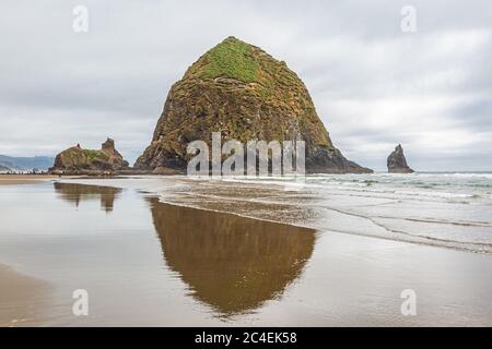 Heuhaufen Rock mit Reflexion, am Cannon Beach an der Küste von Oregon Stockfoto