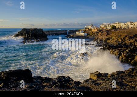 Große Wellen Rollen in den Hafeneingang El Cotillo Fuerteventura Kanarische Inseln Spanien im Abendlicht Stockfoto