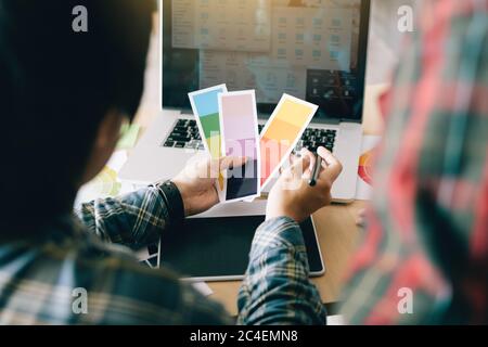 Rückansicht des Designers, der zusammen arbeitet und Farben wählt. Stockfoto