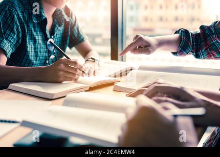 Gruppe von Studenten, die am Schreibtisch in einer öffentlichen Bibliothek studieren und Brainstorming durchführen. Stockfoto
