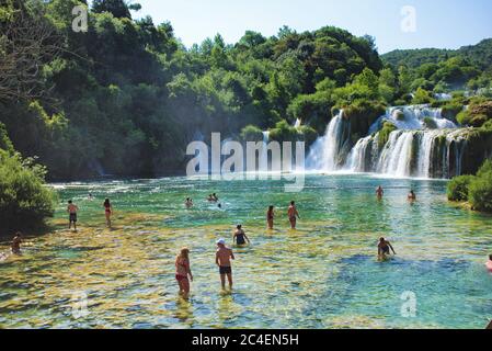 SKRADIN, KROATIEN - 8. JULI 2018: Touristen baden in einem Wasserfall im Nationalpark Krka in Skradin Stadt in Kroatien Stockfoto