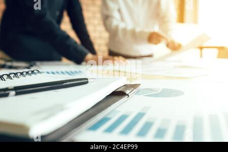 Zwei Geschäftsleute in einer Sitzung und stehend am Sitzungstisch mit Diskussion. Stockfoto